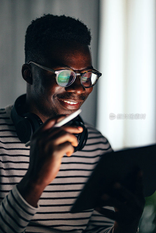 Smiling BusinessmanÂ Working At Home On A Digital Tablet